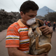 A resident cradles his dog after rescuing him in the wake of Fuego’s eruption.